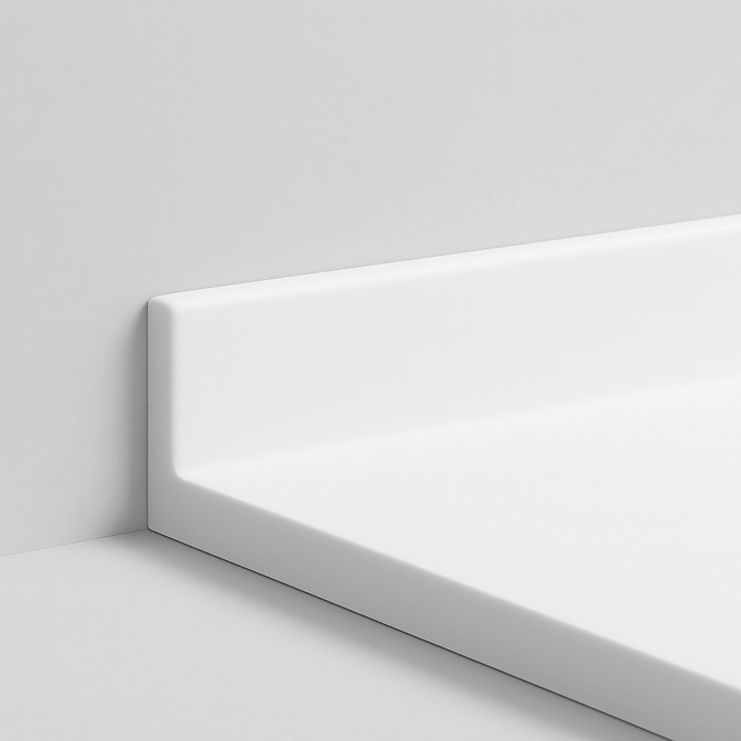 Белый плинтус из акрилового камня, плавно переходящий в столешницу, с бесшовным соединением на светлом фоне.